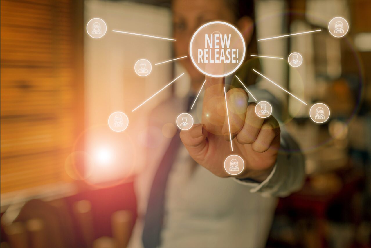 Conceptual hand writing showing New Release. Business photo showcasing announcing something newsworthy recent product Woman wear suit presenting presentation using smart device.